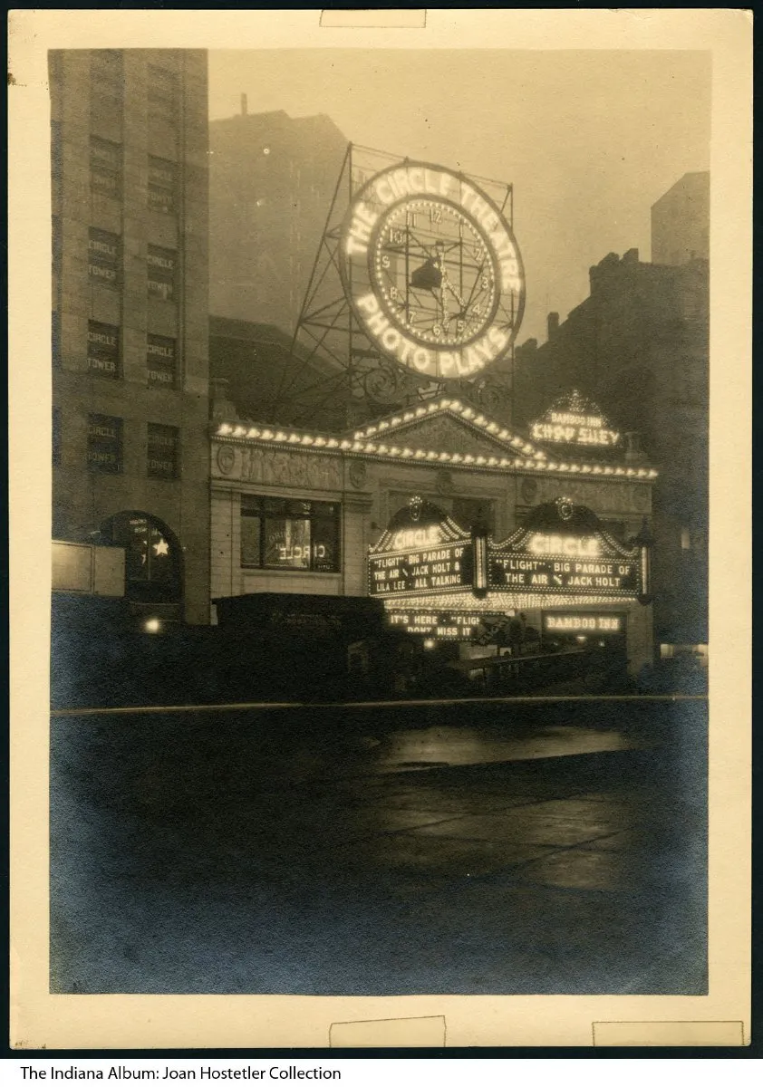 A black and white photo of the Circle Theater in Indianapolis at night time, featuring lighted signs and marquis. At the right side of the building is a lighted sign that reads Bamboo Inn. Above the building is another sign that reads Bamboo Inn Chop Suey.
