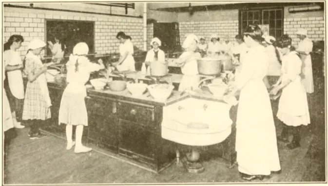 A historic photo of girls wearing arpons gather around tables of bowls during a cooking class