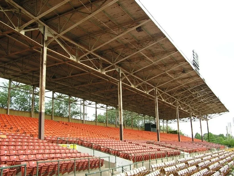 Stadium seating at Bush Stadium, partially covered by an overhang supported by metal trusses