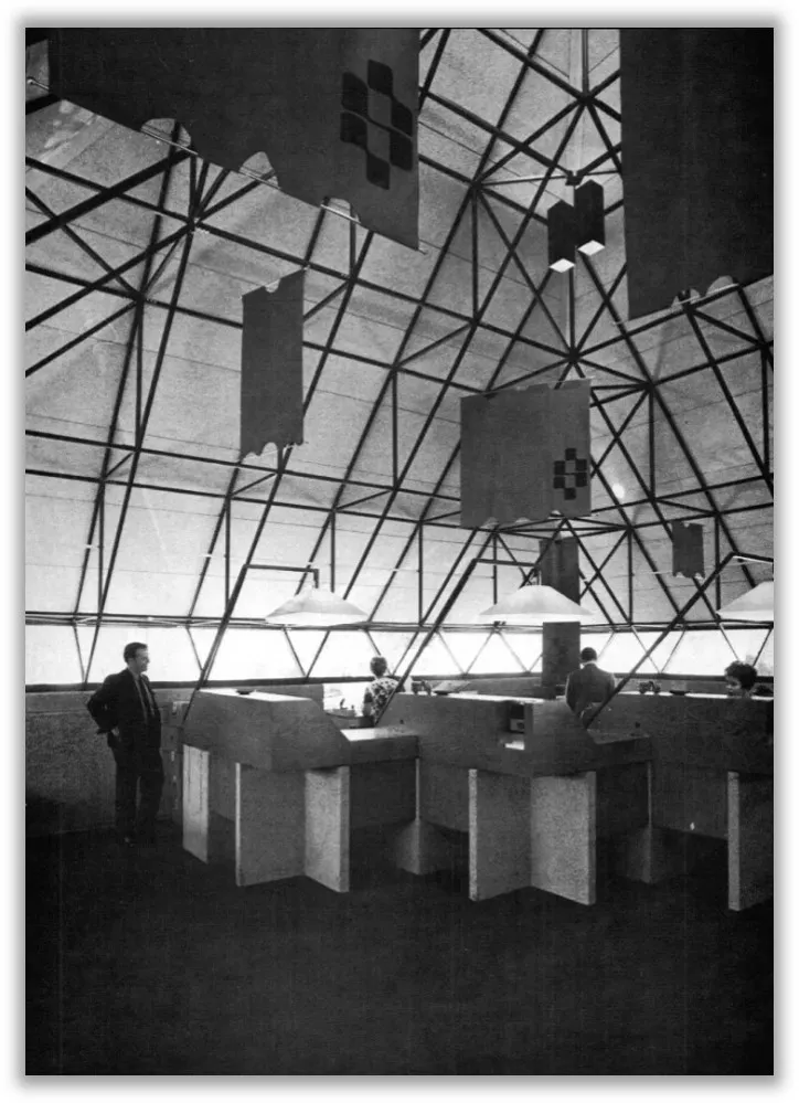 A black and white photo shows the interior of the Pyramid Branch of Peoples Trust Bank in Fort Wayne, showing the roof structure and employees working in an open office setting